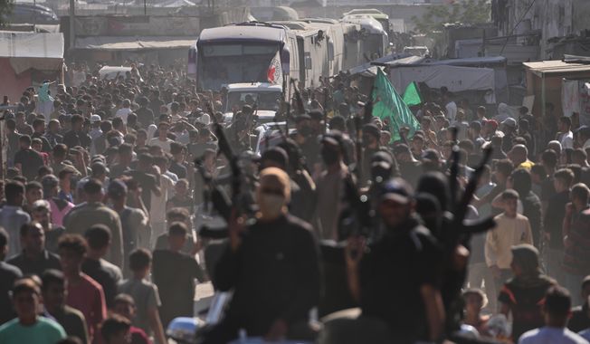 Hamas gunmen in escort buses carrying freed Palestinian prisoners arriving in the Gaza Strip after their release from Israeli jails under a ceasefire agreement between Hamas and Israel, in Khan Younis, southern Gaza Strip, Monday, Oct. 13, 2025. (AP Photo/Jehad Alshrafi)
