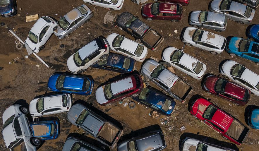 Damaged vehicles sit in mud after flooding in Poza Rica, Veracruz state, Mexico, Sunday, Oct. 12, 2025. (AP Photo/Felix Marquez)