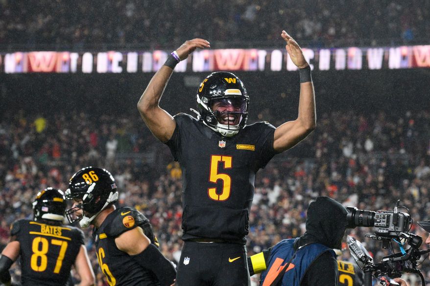 Washington Commanders quarterback Jayden Daniels (5) celebrates a touchdown pass during the second half of an NFL football game against the Chicago Bears, Monday, Oct. 13, 2025, in Landover, Md. (AP Photo/Nick Wass)