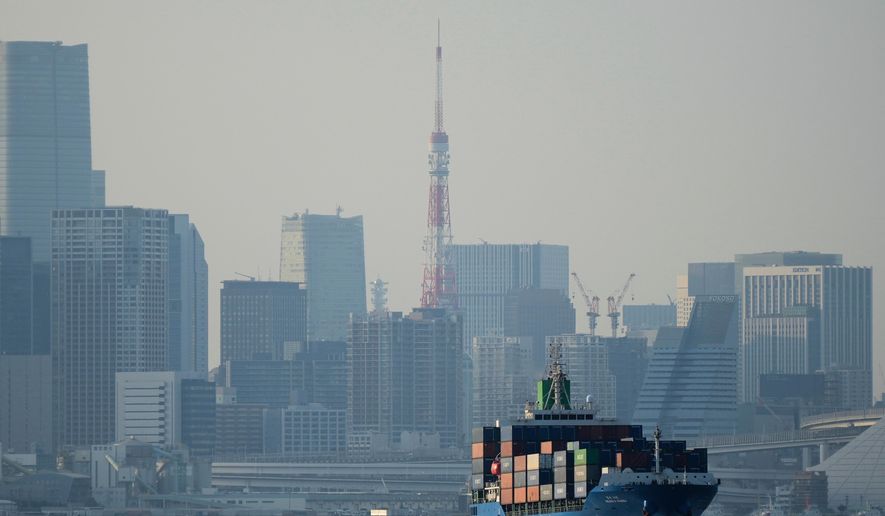 FILE - Tokyo Tower is visible amid tall buildings as a container ship leaves a cargo terminal in Tokyo, April 9, 2025. (AP Photo/Hiro Komae, File)