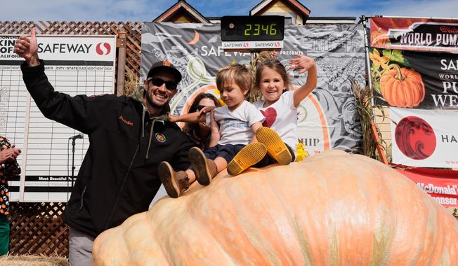 From left, Brandon Dawson celebrates with his children Roman and Ayla after winning the Safeway 52nd annual World Championship Pumpkin Weigh-Off in Half Moon Bay, Calif., Monday, Oct. 13, 2025. (AP Photo/Godofredo A. Vásquez)