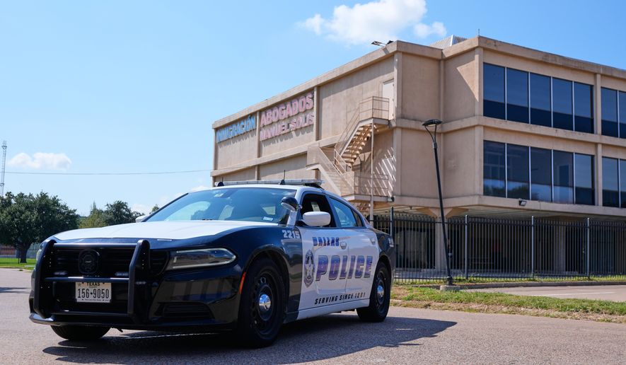 A Dallas police officer's vehicle blocks the road near a crime scene by a U.S. Immigration and Customs Enforcement office Thursday, Sept. 25, 2025, in Dallas. (AP Photo/Tony Gutierrez)