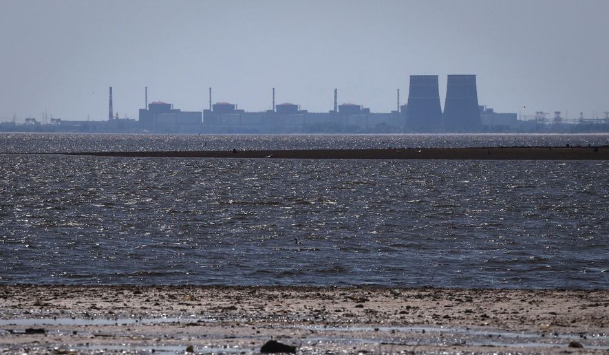 The Zaporizhzhia nuclear power plant, Europe's largest, stands in the background of the shallow Kakhovka Reservoir after the dam collapse, in Energodar, Russian-occupied Ukraine, June 9, 2023. (AP Photo/Kateryna Klochko, File)