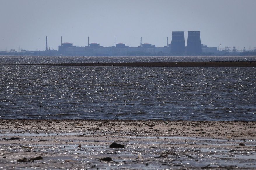 The Zaporizhzhia nuclear power plant, Europe's largest, stands in the background of the shallow Kakhovka Reservoir after the dam collapse, in Energodar, Russian-occupied Ukraine, June 9, 2023. (AP Photo/Kateryna Klochko, File)