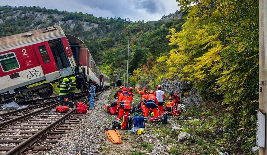 In this photo released by Slovak Police, rescue workers treat wounded passengers after a train crash near Roznava, Slovakia, Monday, Oct. 13, 2025. (Slovak Police via AP)