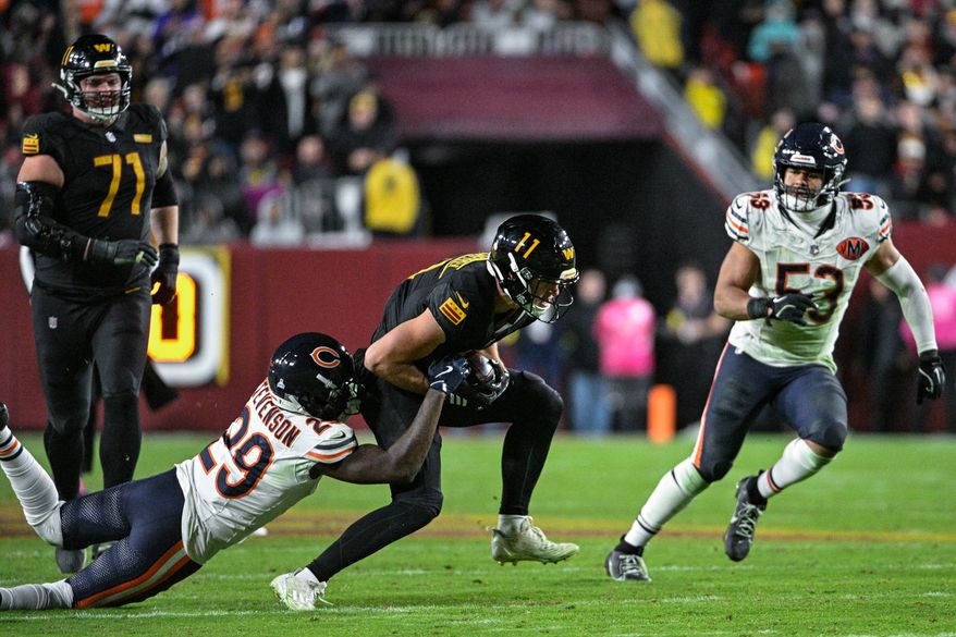 Washington Commanders receiver Luke McCaffrey (11) fights for extra yards as Chicago Bears defensive back Tyrique Stevenson (29) tries to drag him to the ground at Northwest Stadium in Landover, Maryland, October 13, 2025. (Photo by Brian Murphy for the Washington Times)