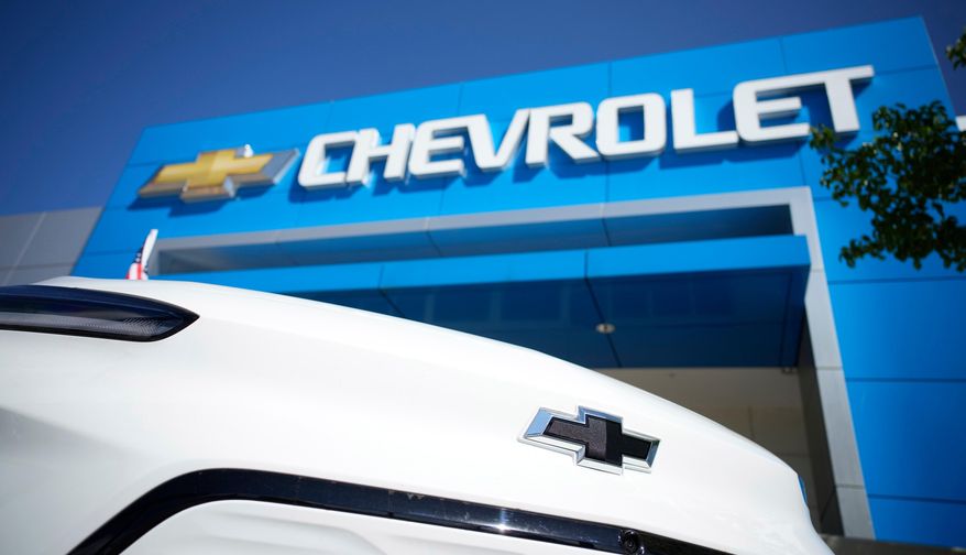 The company logo shines off the nose of an unsold 2022 Bolt electric vehicle on display in front of a Chevrolet dealership Sunday, Sept. 12, 2021, in Englewood, Colo. (AP Photo/David Zalubowski, File)