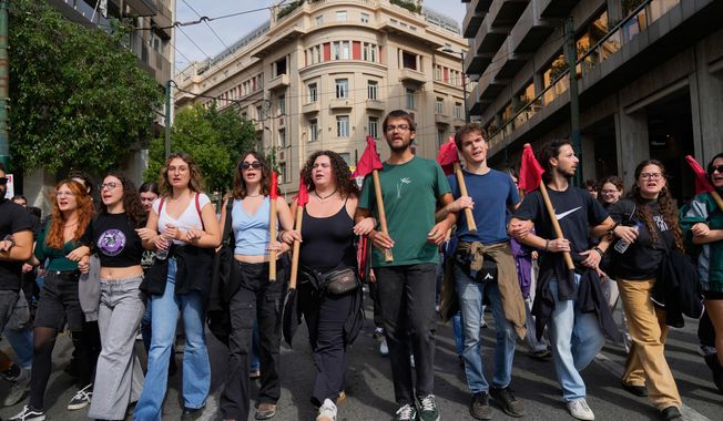 Protesters take part in a nationwide 24-hour strike in Athens, Greece, Tuesday, Oct. 14, 2025, as labor unions demand higher wages and the withdrawal of a bill changing work hours. (AP Photo/Petros Giannakouris)