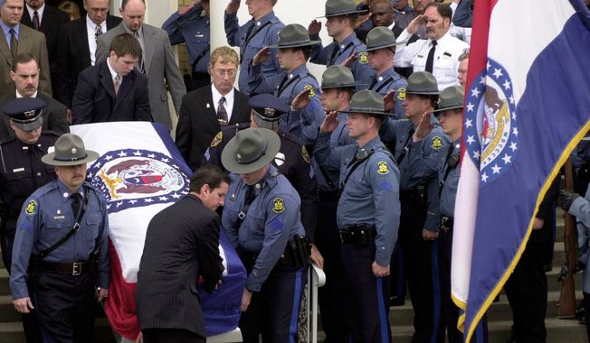 FILE - Members of the Missouri State Highway Patrol salute the body of fellow officer Sgt. Carl ''Dewayne'' Graham Jr., after funeral services March 24, 2005, in Dexter, Mo. (AP Photo/Bill Boyce, File)