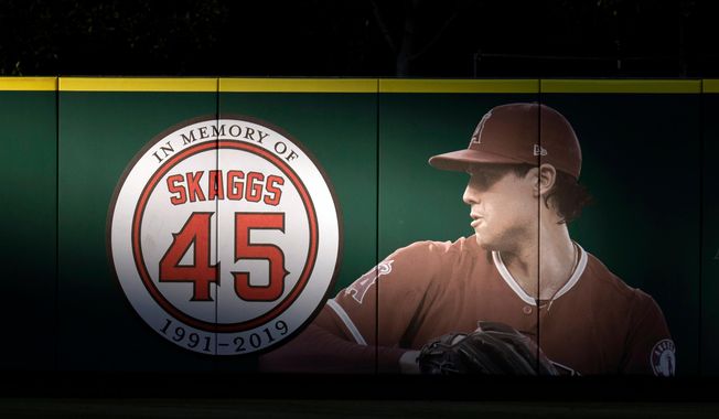 FILE - An image and logo memorializing former Los Angeles Angels pitcher Tyler Skaggs is displayed on the outfield wall in Anaheim, Calif., July 17, 2019. (AP Photo/Kyusung Gong, File)