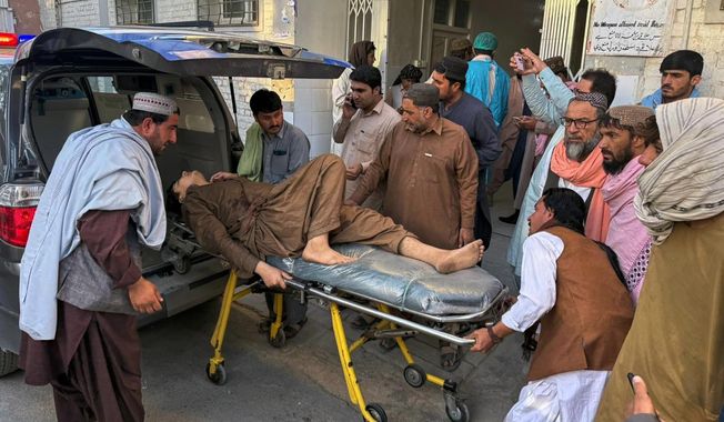 People bring a man, who was injured in the clashes between Pakistan and Afghan forces in border area, for medical treatment at a hospital in Chaman, a town on the Pakistan side of the border, Wednesday, Oct. 15, 2025. (AP Photo/H. Achakzai)