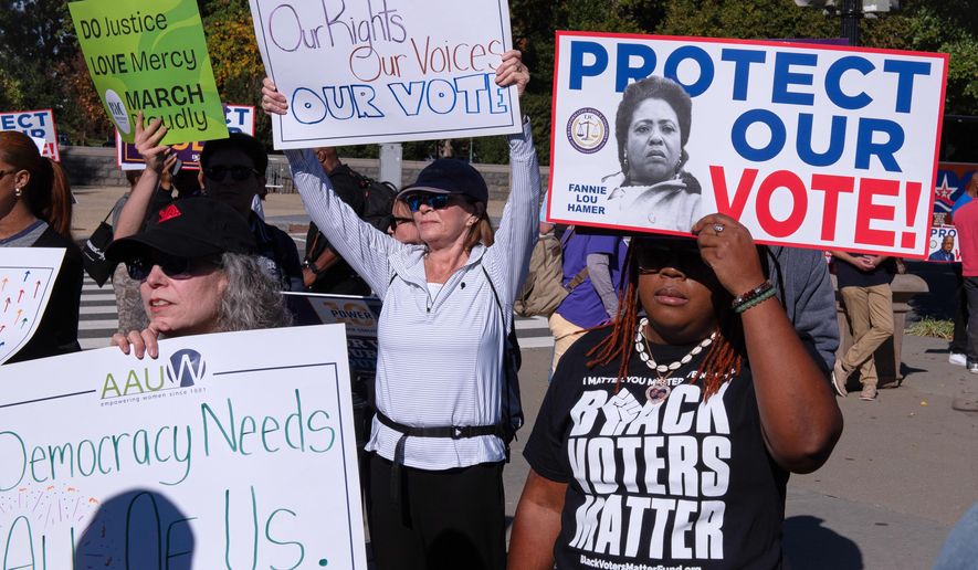 Voting rights activists gather outside the Supreme Court in Washington, early Wednesday, Oct. 15, 2025, as the justices prepare to take up a major Republican-led challenge to the Voting Rights Act, the centerpiece legislation of the Civil Rights Movement. (AP Photo/Cliff Owen)