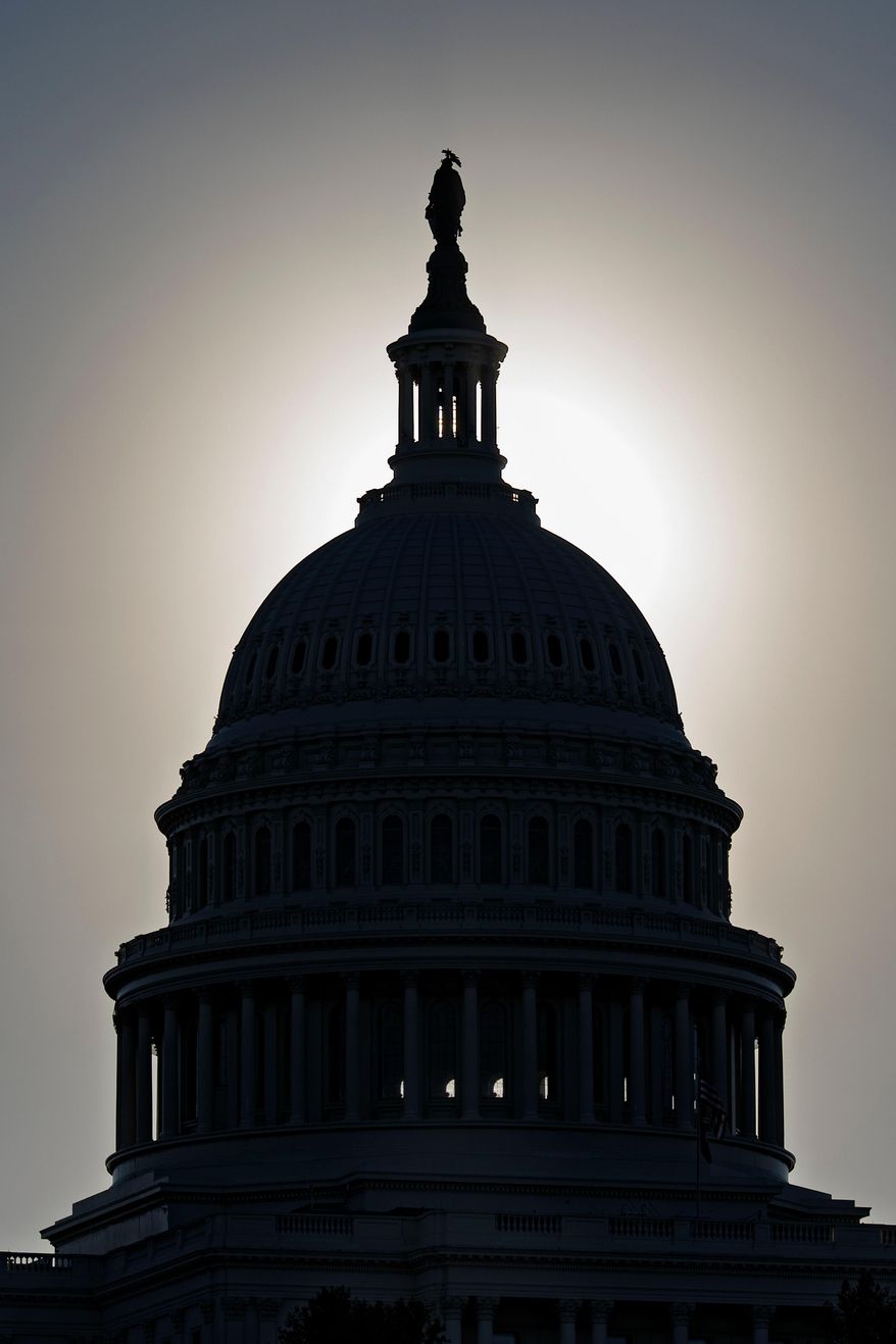 FILE - The U.S. Capitol is silhouetted by the stark glare of the morning sun as a government shutdown begins its tenth day, in Washington, Friday, Oct. 10, 2025. (AP Photo/J. Scott Applewhite, File)