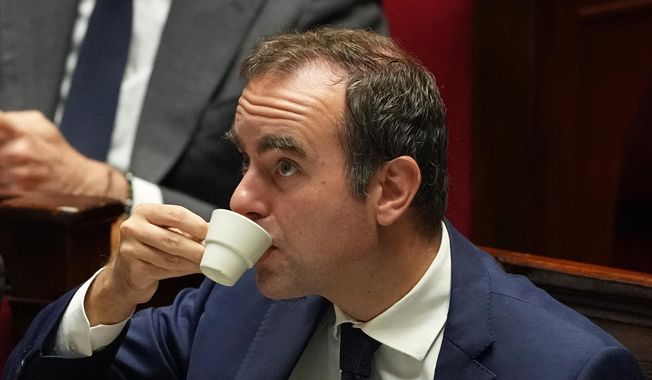 French Prime Minister Sebastien Lecornu drinks as he listens to speeches before a no-confidence vote, Thursday, Oct. 16, 2025 at the National Assembly in Paris. (AP Photo/Thibault Camus)