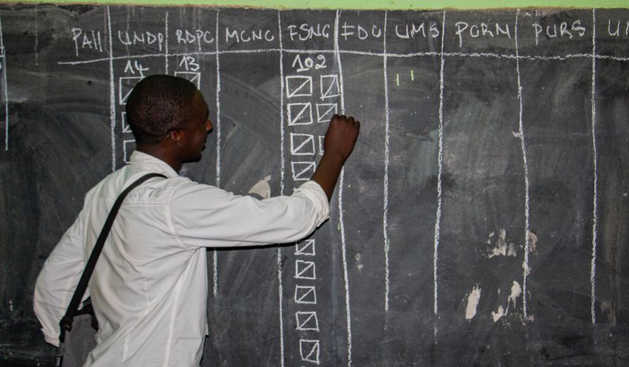An election official fills out a tally on a board during the counting of ballots in Garoua, Cameroon, Sunday, Oct. 12, 2025. (AP Photo/Welba Yamo Pascal)