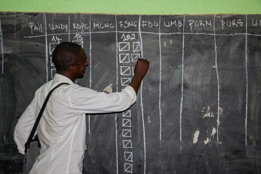 An election official fills out a tally on a board during the counting of ballots in Garoua, Cameroon, Sunday, Oct. 12, 2025. (AP Photo/Welba Yamo Pascal)