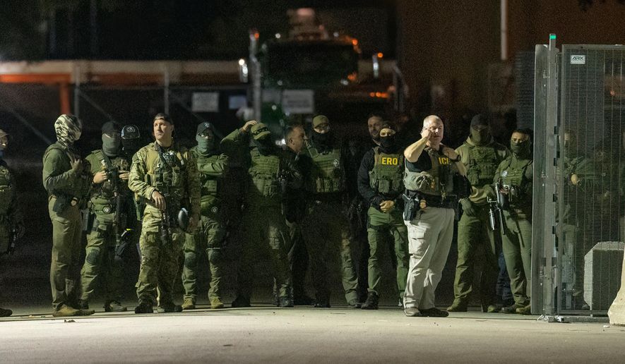 Federal law enforcement officers stand guard in the open gate of the fence built on Beach Street outside the Broadview ICE processing facility in suburban Broadview, Tuesday, Oct. 14, 2025. (Tyler Pasciak LaRiviere/Chicago Sun-Times via AP)