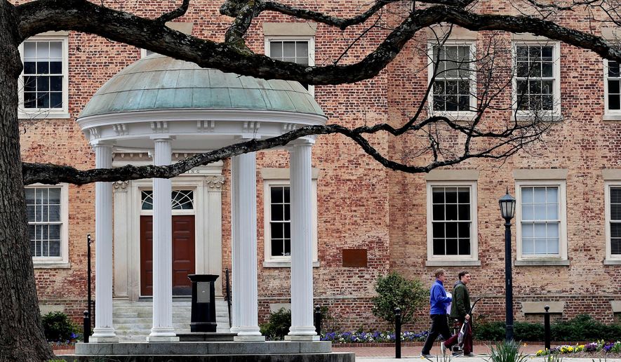 FILE - People walk through University of North Carolina campus March 18, 2020, in Chapel Hill, N.C. (AP Photo/Gerry Broome, File)