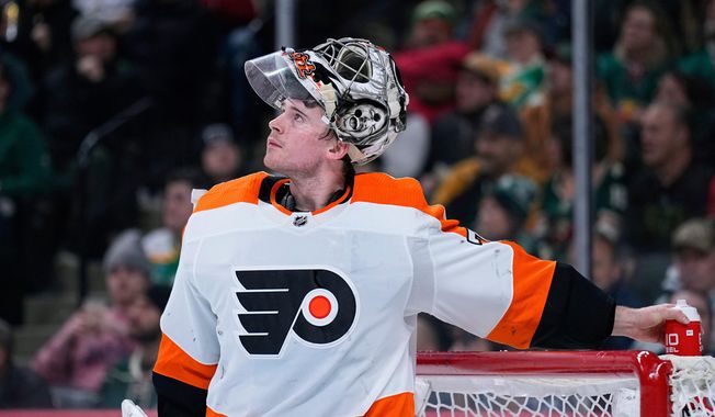 FILE - Philadelphia Flyers goaltender Carter Hart waits for play to resume during the third period of an NHL hockey game against the Minnesota Wild, Thursday, Jan. 26, 2023, in St. Paul, Minn. (AP Photo/Abbie Parr, File)