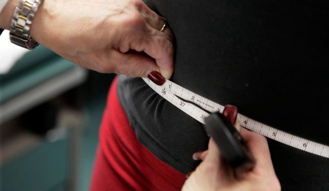 FILE - A subject's waist is measured during an obesity prevention study in Chicago on Jan. 20, 2010. (AP Photo/M. Spencer Green, File)