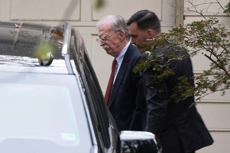 John Bolton, left, who served as President Donald Trump's national security adviser during his first term, leaves his house in Bethesda Md., Friday, Oct. 17, 2025. (AP Photo/Manuel Balce Ceneta)