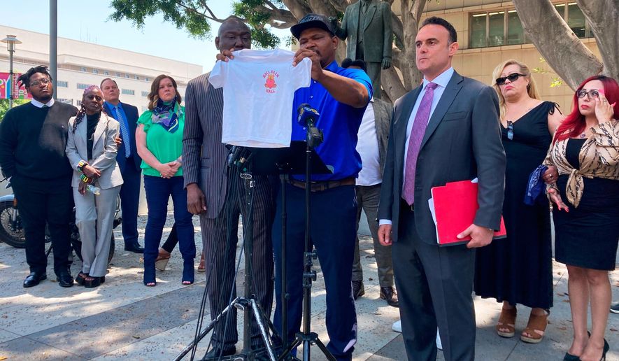 FILE - Jonathan Wright, 39, holds up the T-shirt he was given when he first went to MacLaren Children's Center in El Monte as an 8-year-old during a news conference in Los Angeles, June 9, 2022. (AP Photo/Christopher Weber, File)