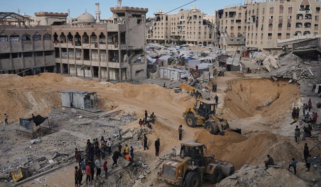 Palestinians watch members of the Hamas militant group searching for bodies of the hostages in an area in Hamad City, Khan Younis, in the southern Gaza Strip, Saturday, Oct. 18, 2025. (AP Photo/Jehad Alshrafi)