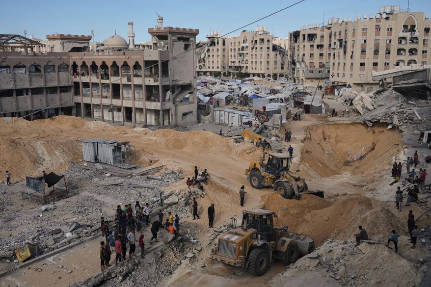 Palestinians watch members of the Hamas militant group searching for bodies of the hostages in an area in Hamad City, Khan Younis, in the southern Gaza Strip, Saturday, Oct. 18, 2025. (AP Photo/Jehad Alshrafi)