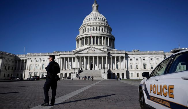 A U.S. Capitol Police officer patrols on the East Front of the U.S. Capitol, Friday, Oct. 17, 2025, in Washington. (AP Photo/Rahmat Gul)