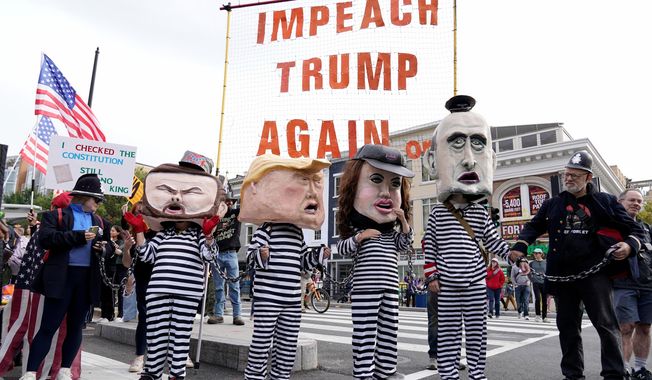 Demonstrators wear costumes and carry signs as they rally at the 14th and U street corridor before marching to the national Mall during a No Kings protest in Washington, Saturday, Oct. 18, 2025. (AP Photo/Jose Luis Magana)