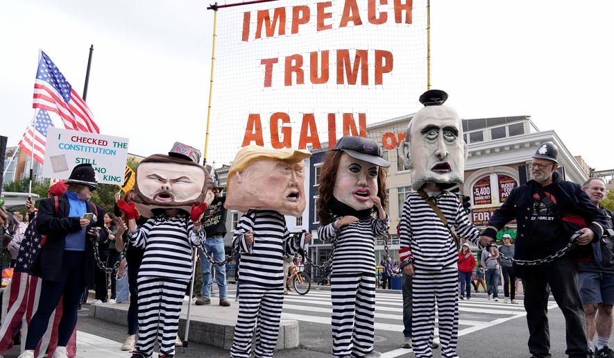 Demonstrators wear costumes and carry signs as they rally at the 14th and U street corridor before marching to the national Mall during a No Kings protest in Washington, Saturday, Oct. 18, 2025. (AP Photo/Jose Luis Magana)