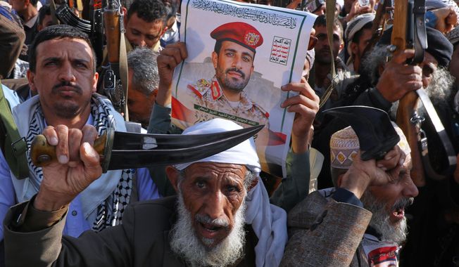Houthi supporters hold a poster of Maj. Gen. Muhammad Abdul Karim al-Ghamari, who died of wounds he suffered after an Israeli attack, during an anti-U.S. and anti-Israel rally in Sanaa, Yemen, Friday, Oct. 17, 2025. (AP Photo/Osamah Abdulrahman)