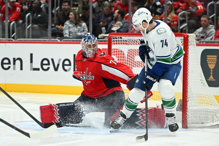 Washington Capitals goalie Charlie Lindgren (79) sliding over to make a save on Vancouver Canucks forward Jake DeBrusk (74) during the second period of an NHL game at Capital One Arena in Washington D.C., October 19, 2025. (Photo for the Washington Times)