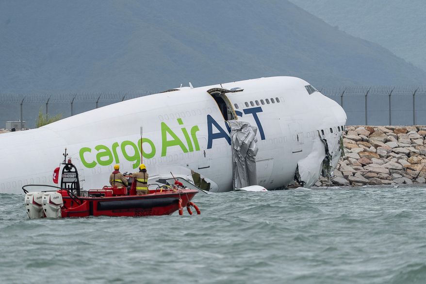 Rescue workers approach a cargo aircraft that skidded off a Hong Kong runway on Monday, Oct. 20, 2025. (AP Photo/Chan Long Hei)