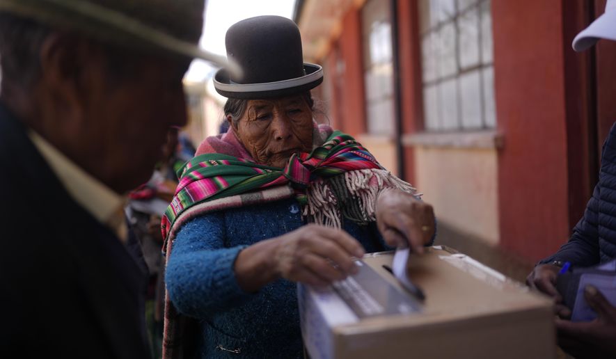 A voter casts her ballot in a presidential runoff election in Warisata, Bolivia, Sunday, Oct. 19, 2025. (AP Photo/Juan Karita)