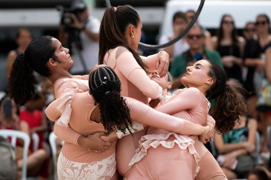 Members of the group aerial circus "Pendurados” perform in an open-air show that explores healing from sexual violence through art and community, at Icarai Beach in Niteroi, Rio de Janeiro state, Brazil, Saturday, Oct. 18, 2025. (AP Photo/Bruna Prado)