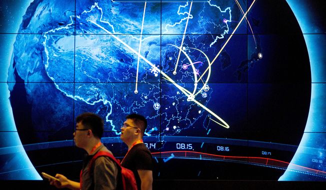 Attendees walk past an electronic display showing recent cyberattacks in China at the China Internet Security Conference in Beijing on Sept. 12, 2017. (AP Photo/Mark Schiefelbein, File)