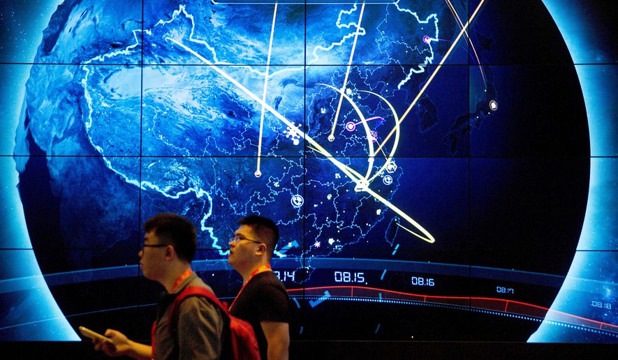 Attendees walk past an electronic display showing recent cyberattacks in China at the China Internet Security Conference in Beijing on Sept. 12, 2017. (AP Photo/Mark Schiefelbein, File)