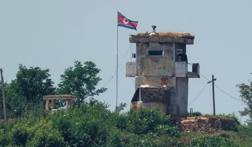 A soldier stands at a North Korean military guard post flying a national flag, seen from Paju, South Korea, June 26, 2024. (AP Photo/Lee Jin-man, File)