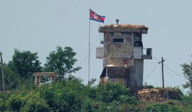 A soldier stands at a North Korean military guard post flying a national flag, seen from Paju, South Korea, June 26, 2024. (AP Photo/Lee Jin-man, File)