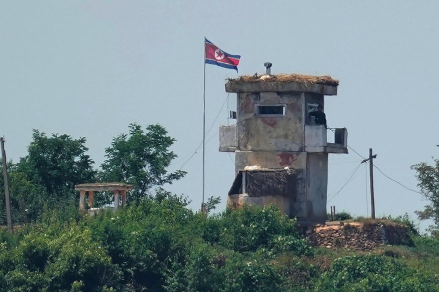 A soldier stands at a North Korean military guard post flying a national flag, seen from Paju, South Korea, June 26, 2024. (AP Photo/Lee Jin-man, File)