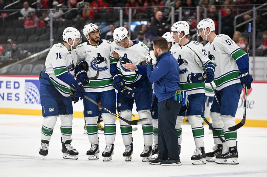Vancouver Canucks center Filip Chytil (72) getting helped off the ice after getting hit by Washington Capitals right wing Tom Wilson (43) during the first period of an NHL game at Capital One Arena in Washington D.C., October 19, 2025. (Photo for the Washington Times)