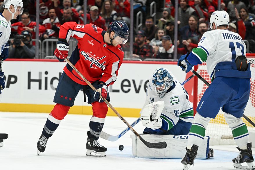 Washington Capitals defenseman Jakob Chychrun (6) in front of the net as defenseman John Carlson’s goal goes in the net during the third period of an NHL game against the Vancouver Canucks at Capital One Arena in Washington D.C., October 19, 2025. (Photo for the Washington Times)