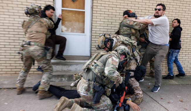 ICE agents detain a protester as other protesters try to stop them in East Side, Chicago, Tuesday, Oct. 14, 2025. (Anthony Vazquez/Chicago Sun-Times via AP)