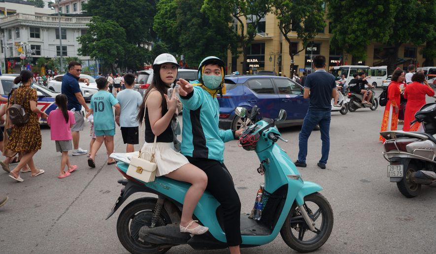 CORRECTS TO CALL THE AREA THE OLD QUARTER - A Vietnamese motorcycle taxi ferries a customer on an EV scooter in the Old Quarter area in Hanoi, Vietnam, on Sept. 1, 2025. (AP Photo/Vincent Thian)