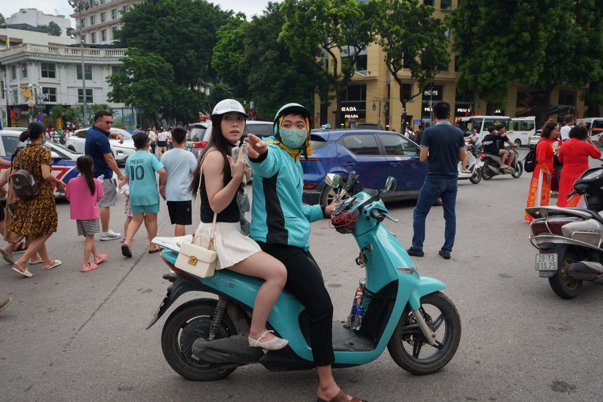 CORRECTS TO CALL THE AREA THE OLD QUARTER - A Vietnamese motorcycle taxi ferries a customer on an EV scooter in the Old Quarter area in Hanoi, Vietnam, on Sept. 1, 2025. (AP Photo/Vincent Thian)