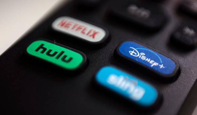 FILE - The logos for streaming services Netflix, Hulu, Disney Plus and Sling TV are pictured on a remote control on Aug. 13, 2020, in Portland, Ore. (AP Photo/Jenny Kane, File)