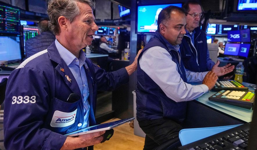 Trader Robert Charmak, left, and specialist Dilip Patel, center, work on the floor of the New York Stock Exchange, Monday, Oct. 13, 2025. (AP Photo/Richard Drew)