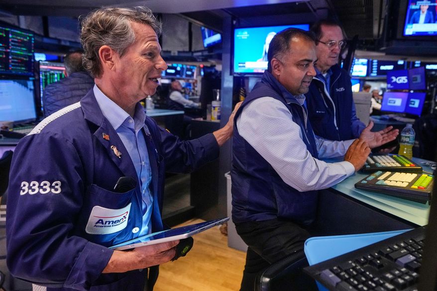 Trader Robert Charmak, left, and specialist Dilip Patel, center, work on the floor of the New York Stock Exchange, Monday, Oct. 13, 2025. (AP Photo/Richard Drew)