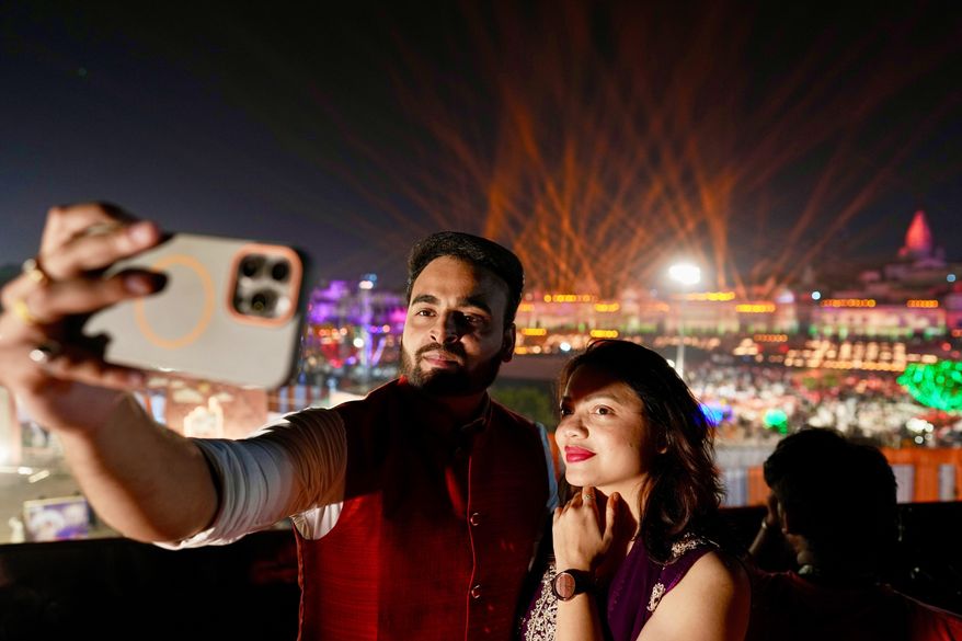 A couple takes a selfie along the Saryu river during Deepotsav celebrations on the eve of Diwali in Ayodhya, India, Sunday, Oct. 19, 2025. (AP Photo/Rajesh Kumar Singh)